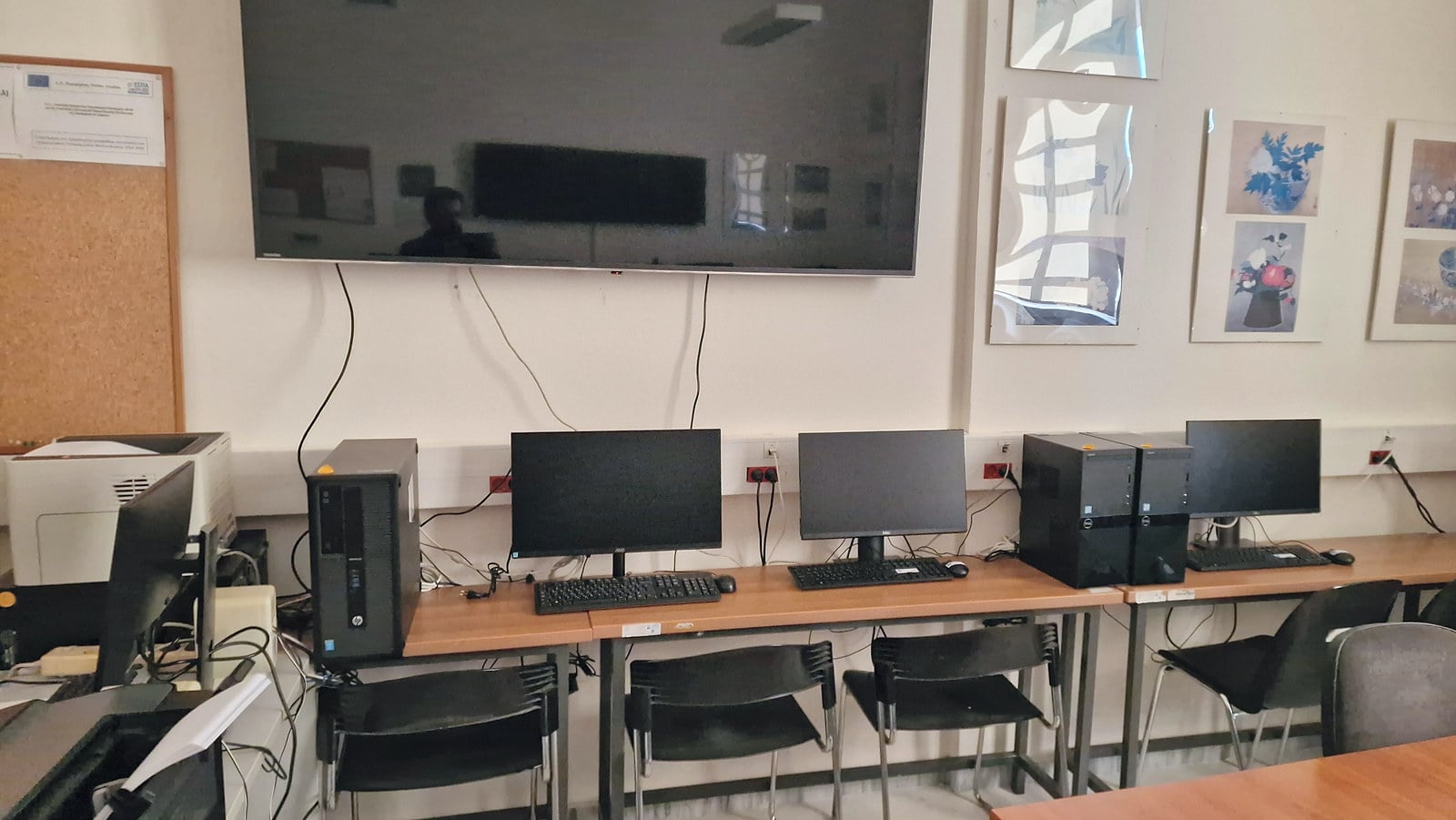 Μεγάλη οθόνη προβολής πάνω από θέσεις εργασίας